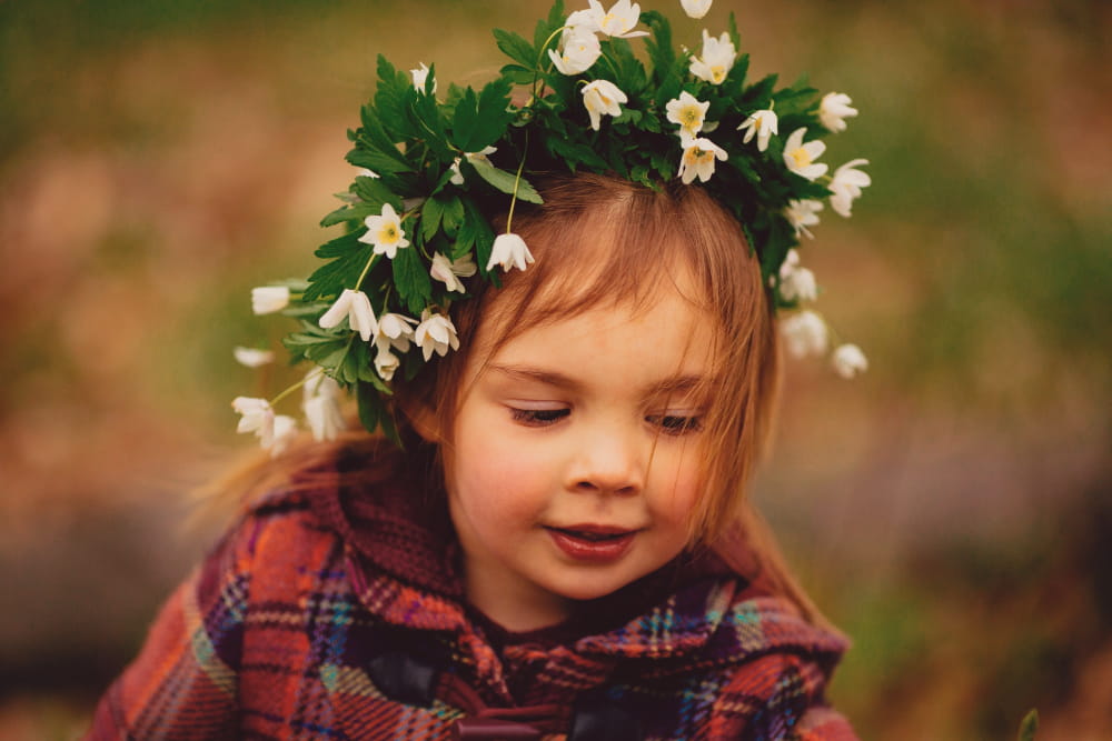 Une enfant dans la nature qui porte une couronne de fleurs
